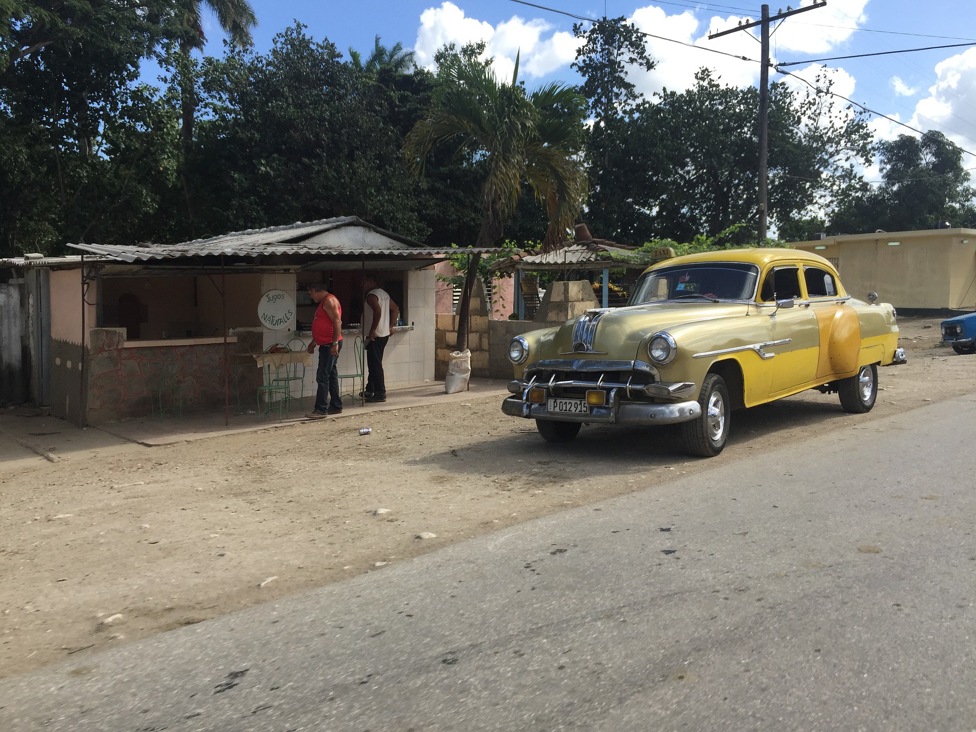 Yellow car in the road in Cuba driving